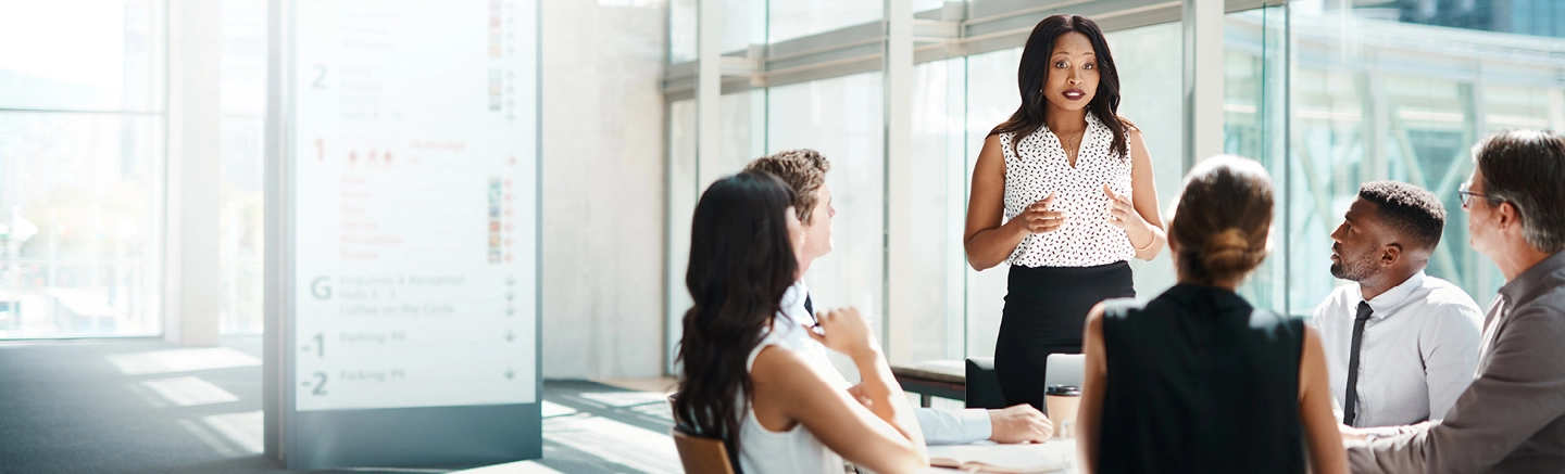 Group of diverse business professionals collaborating with a black woman presenting