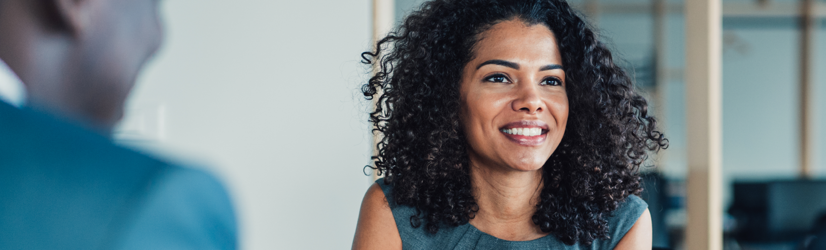 An Introductory guide to successful Recruitment Process Outsourcing or RPO: A woman smiling in an office