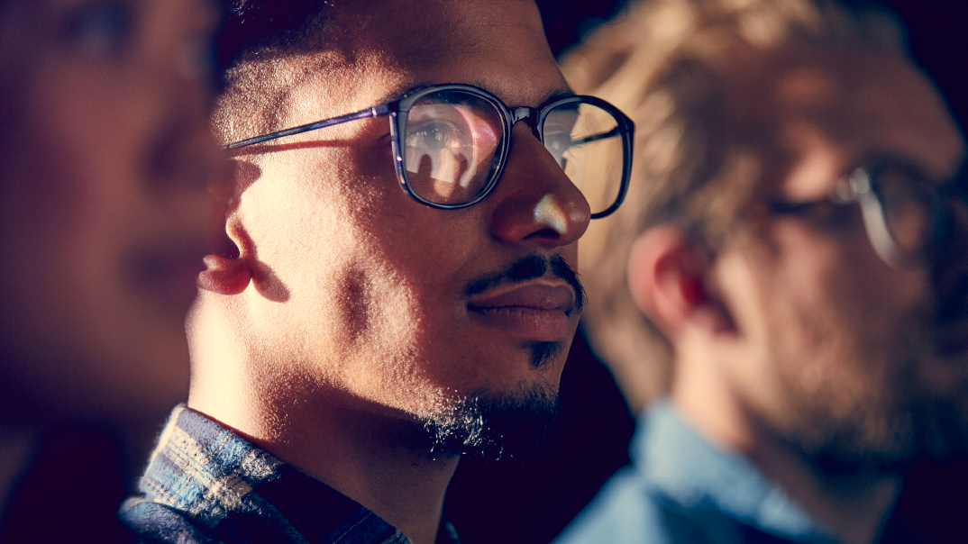 Close up of a man with glasses looking forward.