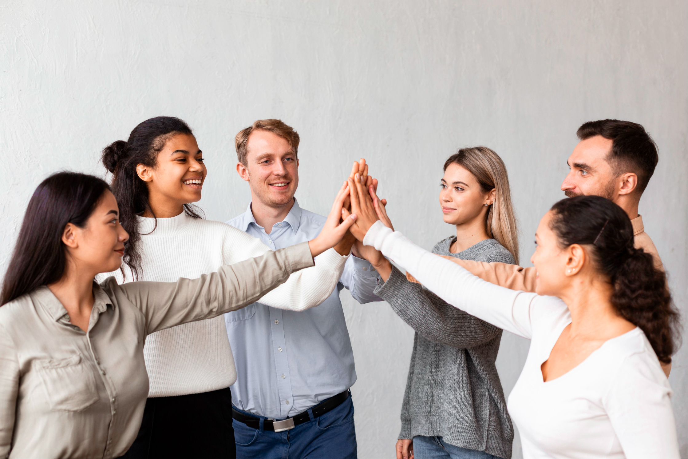 A group of men and women high-five hands in a group.